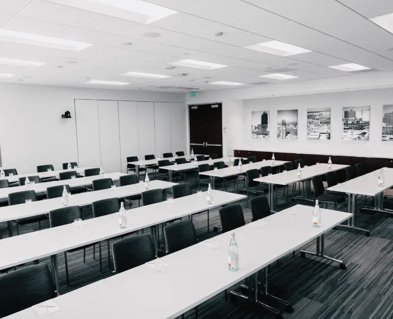 a classroom with tables and chairs and a projector screen