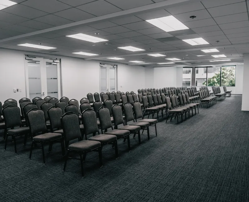a large room with rows of chairs and windows