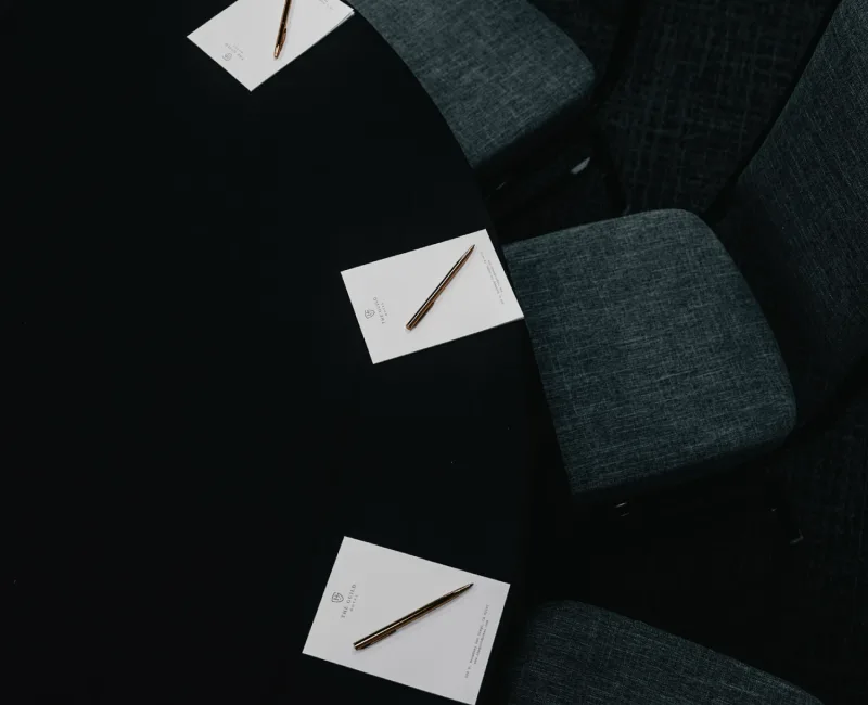a round table with a black table cloth and chairs around it